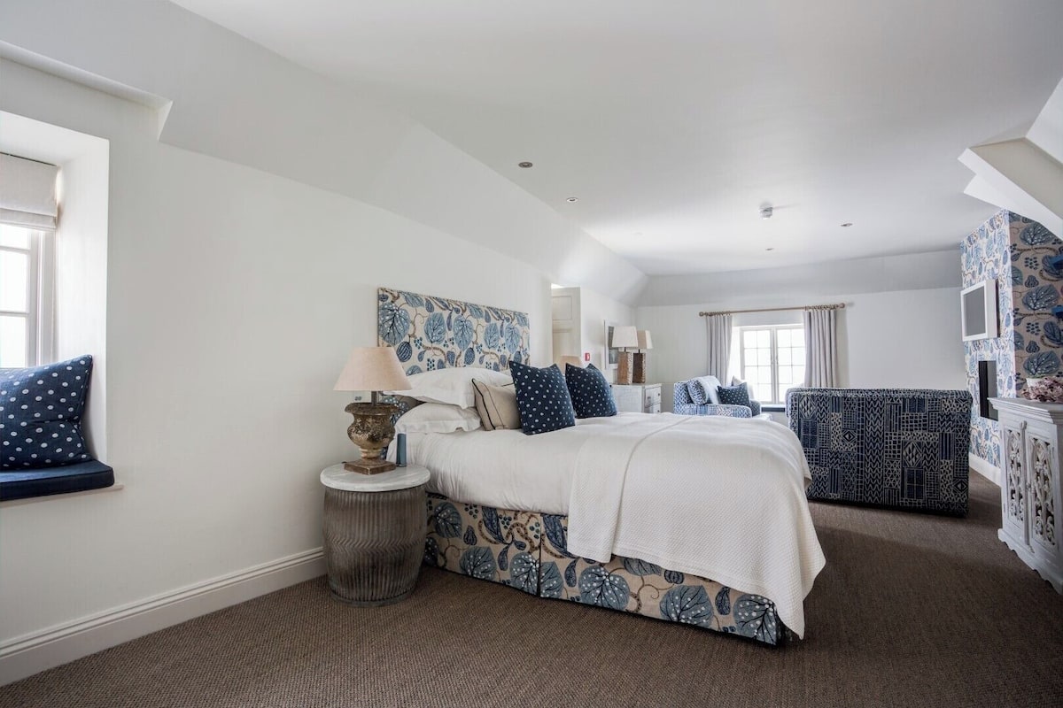 A bedroom with a bed, bedside table, lamp, and patterned headboard.