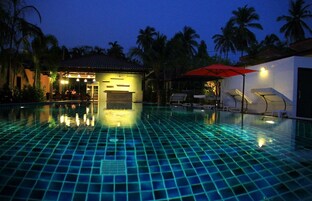 Una piscina al aire libre, sillones reclinables de piscina