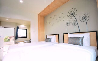 Una habitación de hotel con dos camas, techo de madera y un mural en la pared con diente de león.