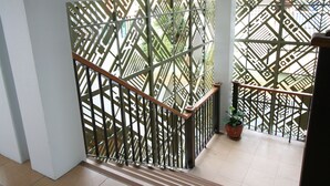 A staircase with a geometric patterned railing and a potted plant on the landing. - Sirimunta Hotel Chiang Rai (Chiang Rai)
