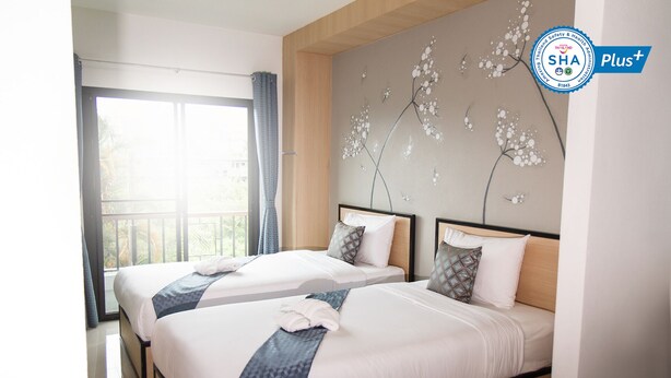 A hotel room with two beds, a large window, and a wall with a floral mural. - Sirimunta Hotel Chiang Rai (Chiang Rai)
