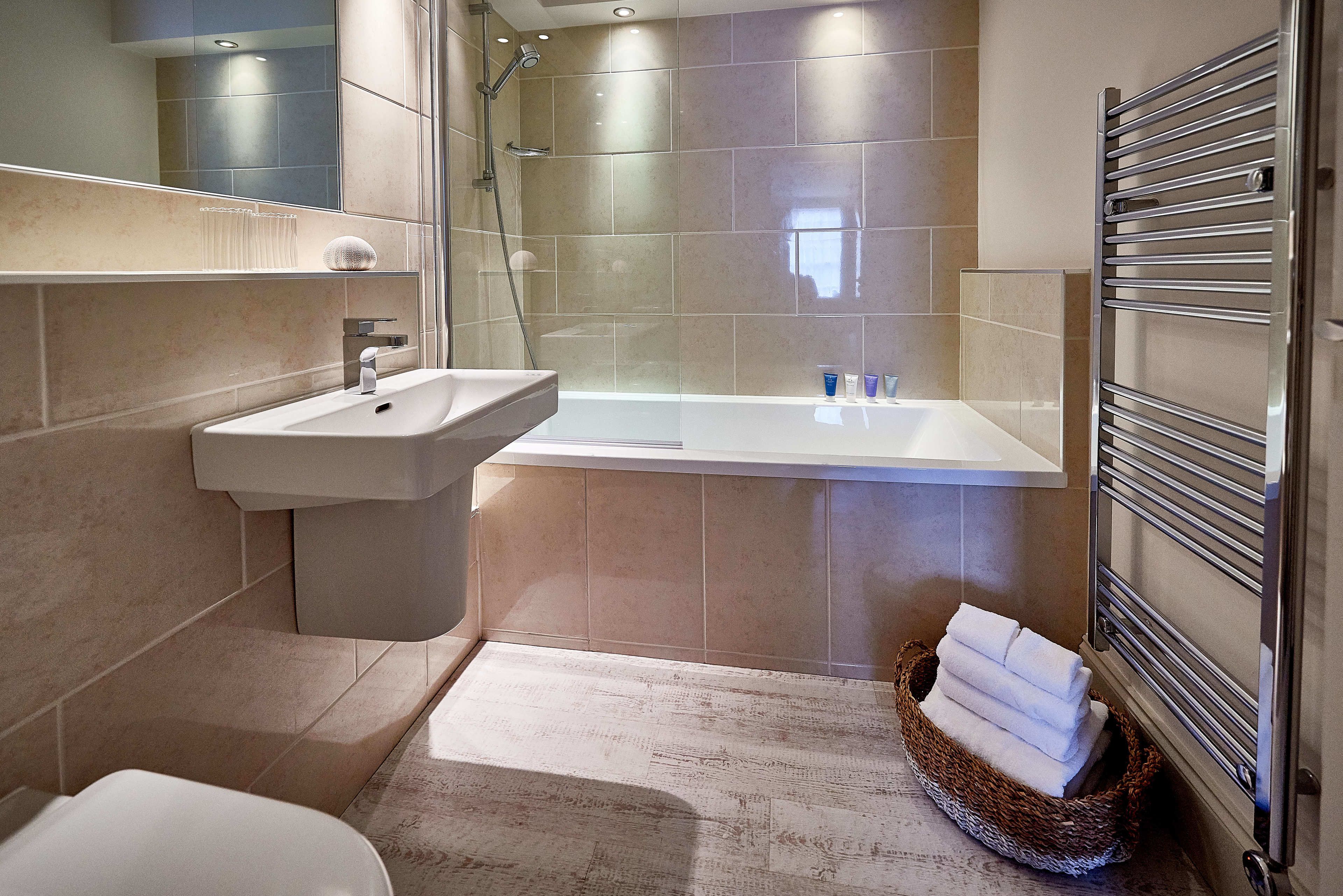 A modern bathroom with a sink, bathtub, and shower.