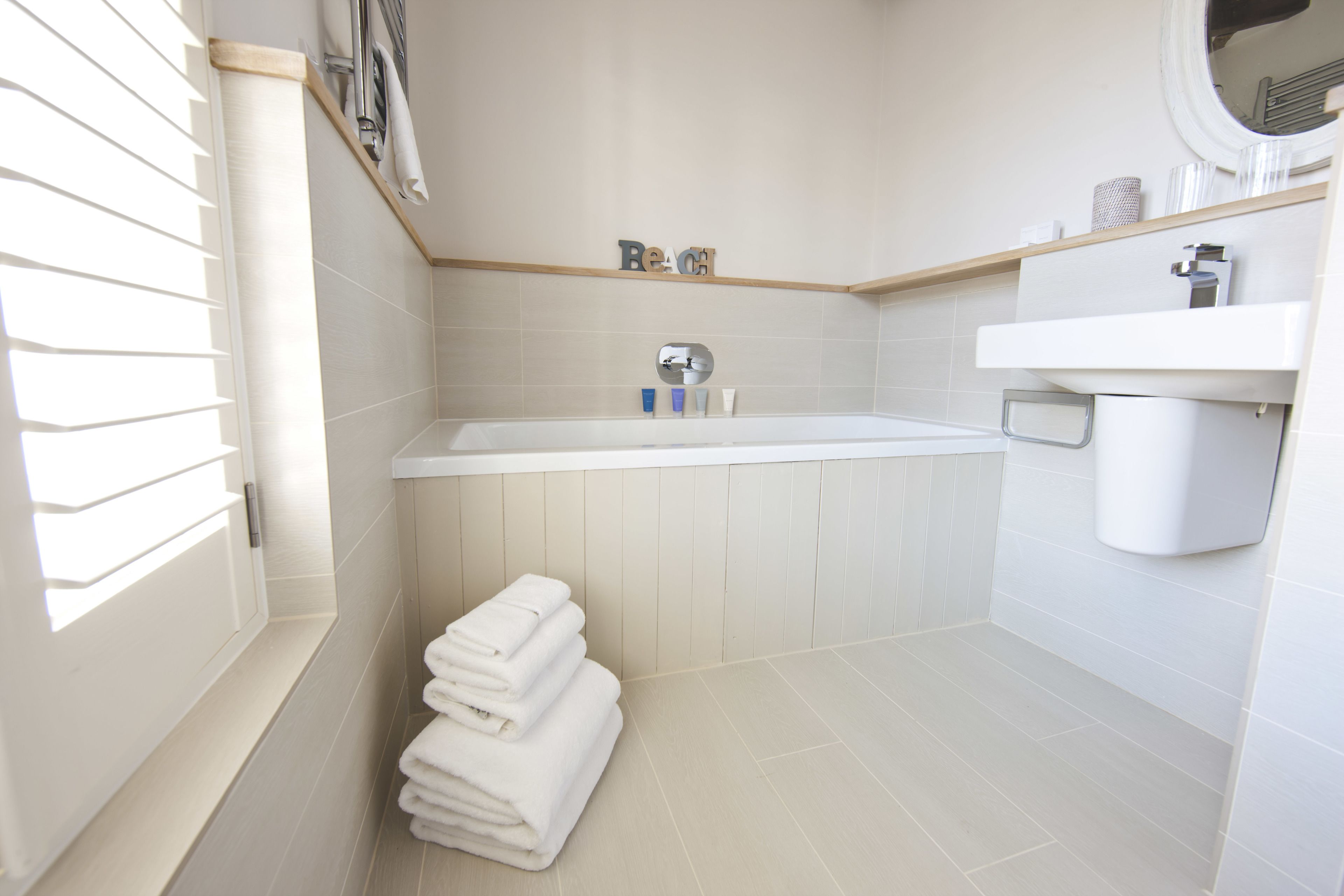 Ein modernes Badezimmer mit einer Badewanne, einem Waschbecken und einem Handtuchhalter.