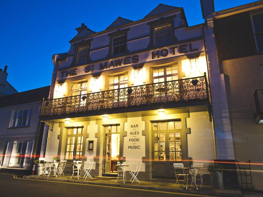 Hotel St Mawes con balcón, bar y mesas al aire libre.