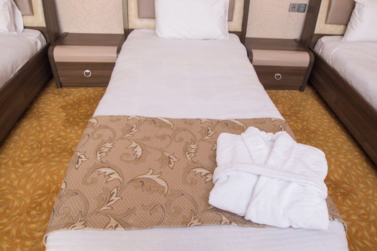 Une chambre d’hôtel avec un grand lit, deux tables de chevet et une salle de bain.