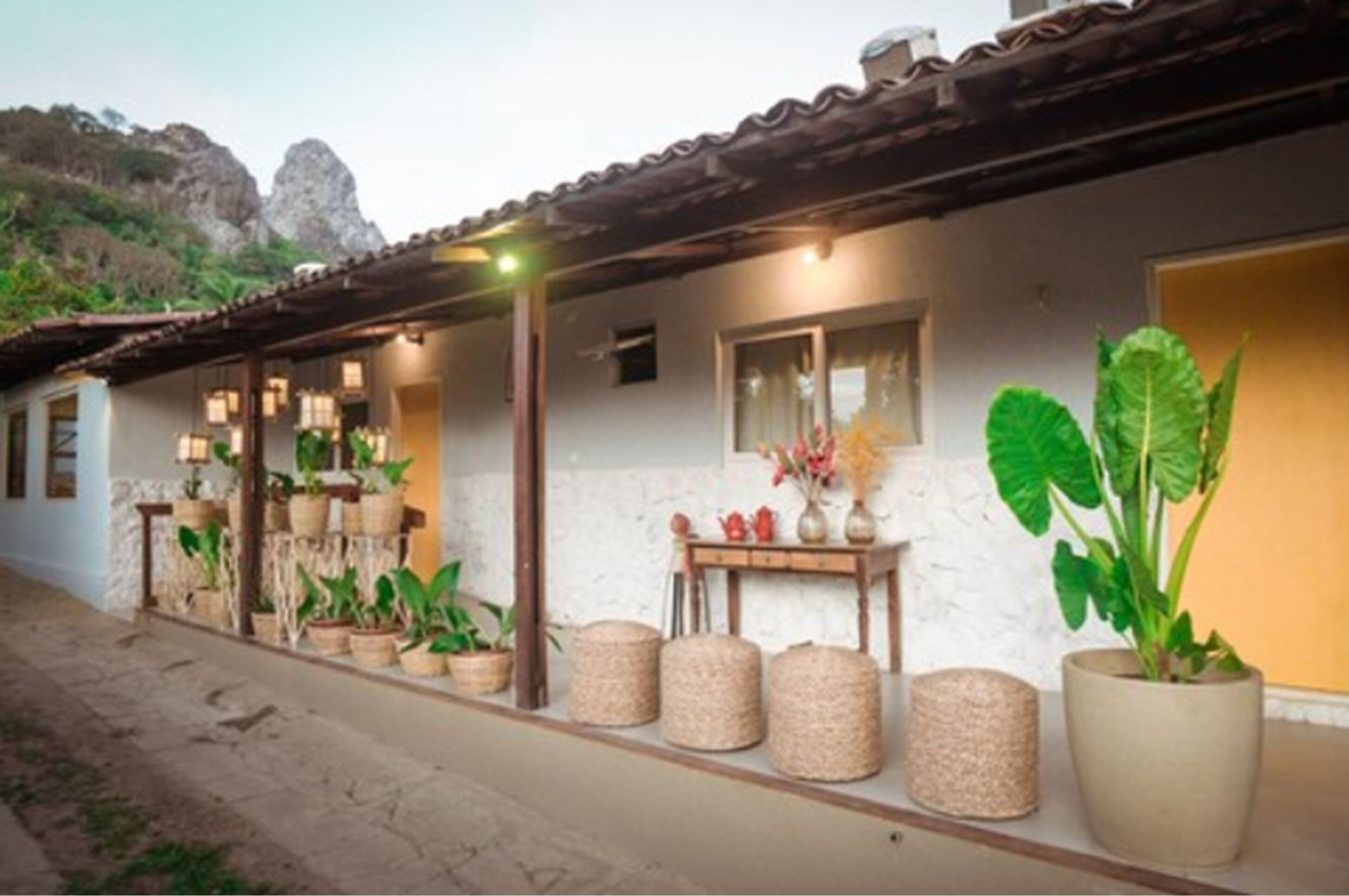 A rustic building with a tiled roof, potted plants, and a small table with decorative items.