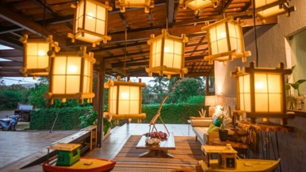 Une pièce de style japonais traditionnel, avec un sol recouvert de tatamis, de petites tables en bois et des lanternes en papier suspendues.