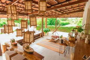 A traditional Japanese-style room with tatami flooring, wooden furniture, and hanging lanterns.