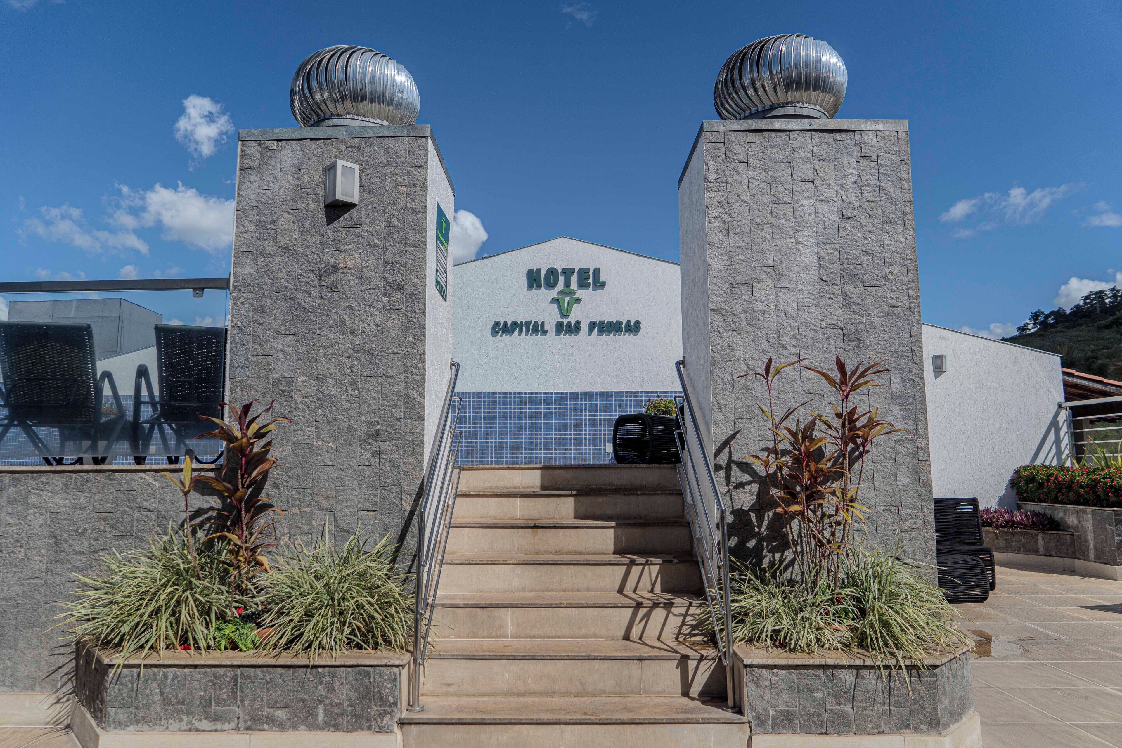 Entrada de um hotel com uma escadaria que leva a uma placa com a inscrição 'HOTEL CAPITAL DAS PEREAS'.