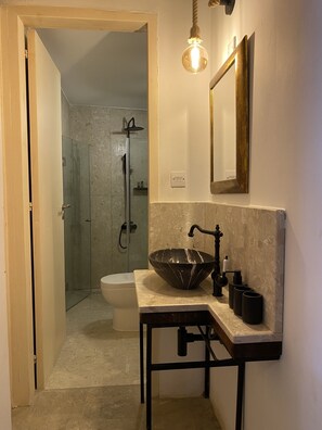 A bathroom with a glass-enclosed shower, a white toilet, and a vessel sink with a black faucet. - SPITI Calliope - ex House of Eleni (Kathikas)