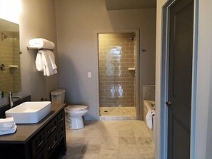 A bathroom with a sink, toilet, and shower area. - Kentucky Grand Hotel & Spa (Bowling Green)