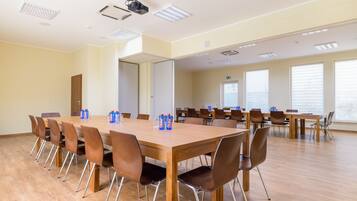 A conference room with a long table, multiple chairs, and a projector.