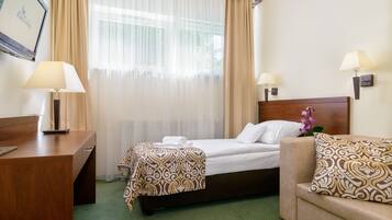 Une chambre d’hôtel avec un lit, un canapé, un bureau et deux lampes.