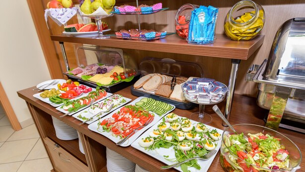 A buffet with various food items including salads, sandwiches, and fruits. - Hotel Zielony (Poznan)