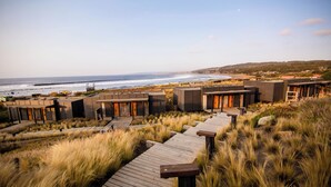 A coastal resort with wooden walkways, beach access, and ocean views. - Hotel Alaia (Pichilemu)