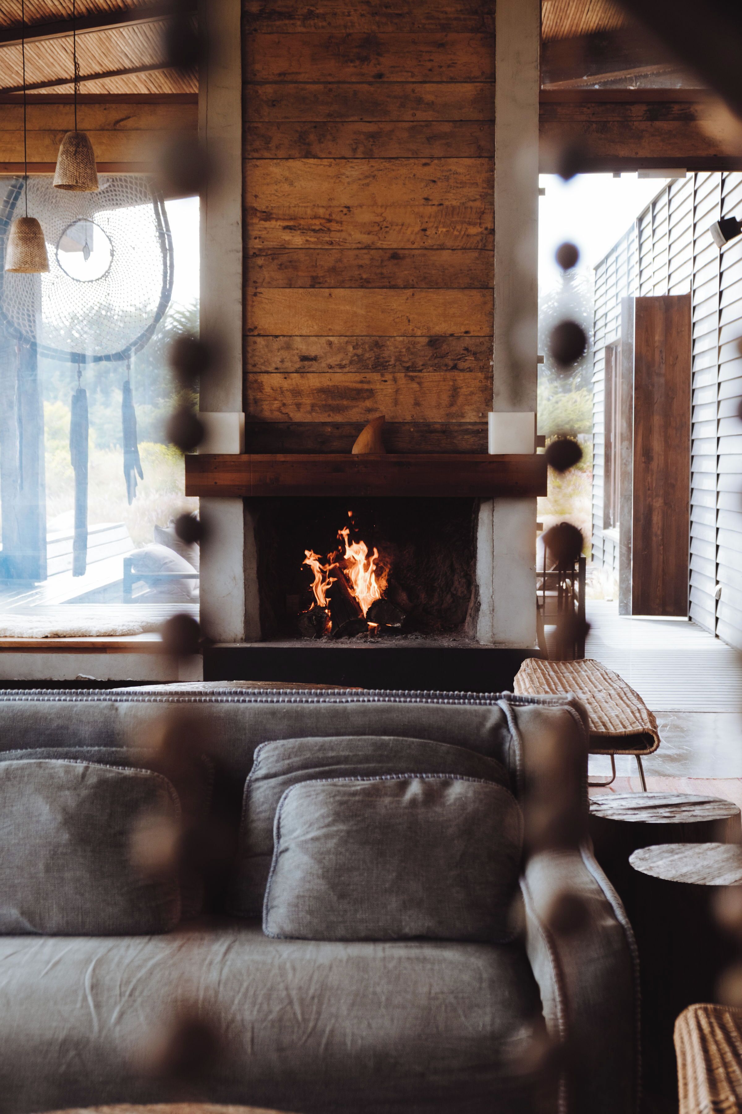 Una sala de estar acogedora con chimenea, sofá de cuero y vistas al exterior.