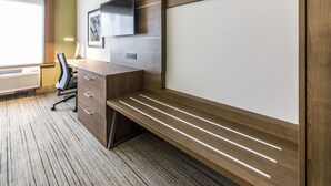 A modern office space with a wooden desk, chair, and built-in shelving. - Holiday Inn Express Villa Rica by IHG (Villa Rica)