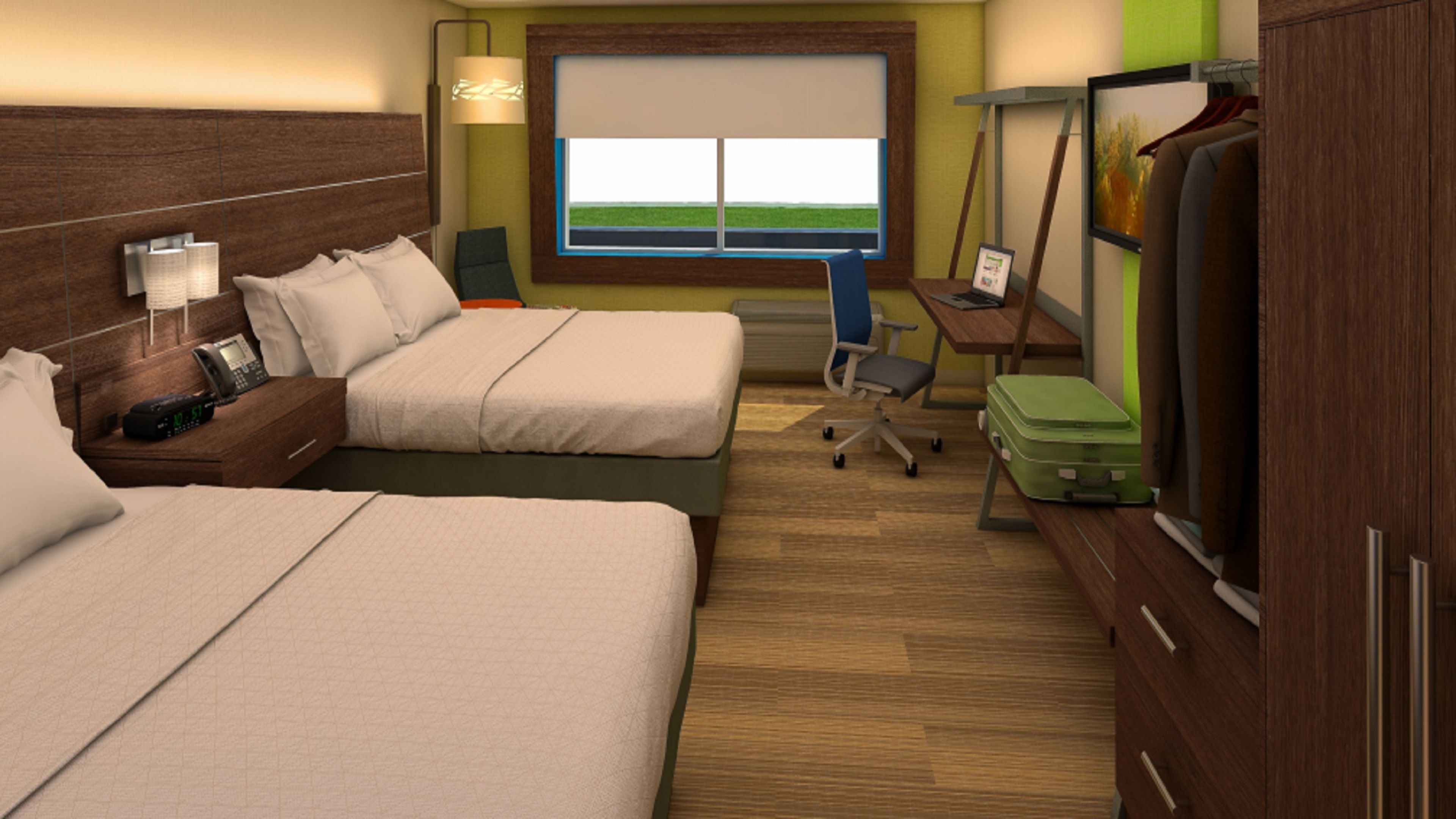 A hotel room with two beds, a desk, a chair, a TV, and a window with a view of the sky.