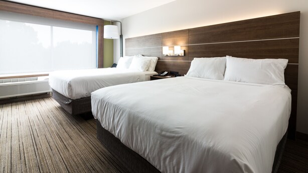 A hotel room with two beds, a large window, a wall-mounted lamp, and a built-in heater. - Holiday Inn Express Villa Rica by IHG (Villa Rica)