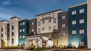 Um hotel Staybridge Suites com fachada moderna, vários andares e área de entrada coberta.