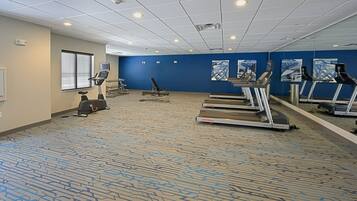 A fitness room with treadmills, a stationary bike, and an elliptical machine.
