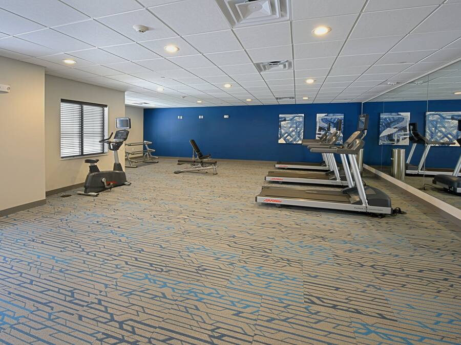 A fitness room with treadmills, a stationary bike, and an elliptical machine.
