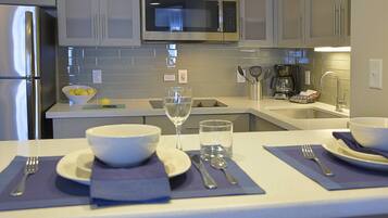 Una cocina moderna con electrodomésticos de acero inoxidable, microondas integrado y cafetera.