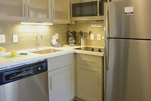 A modern kitchen with stainless steel appliances, a dishwasher, and a coffee maker.