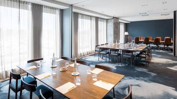 A conference room with a long table, chairs, and a meeting area with tables and chairs.