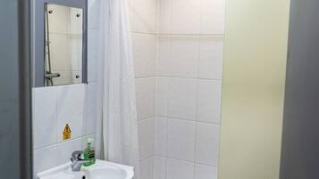 A bathroom with a white sink, a mirror, and a shower curtain.