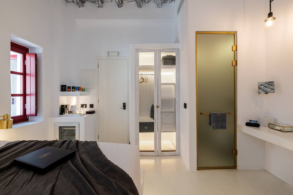 Ein Schlafzimmer mit einem Bett, einem Nachttisch, einem Kleiderschrank, einer Tür und einem Fenster.