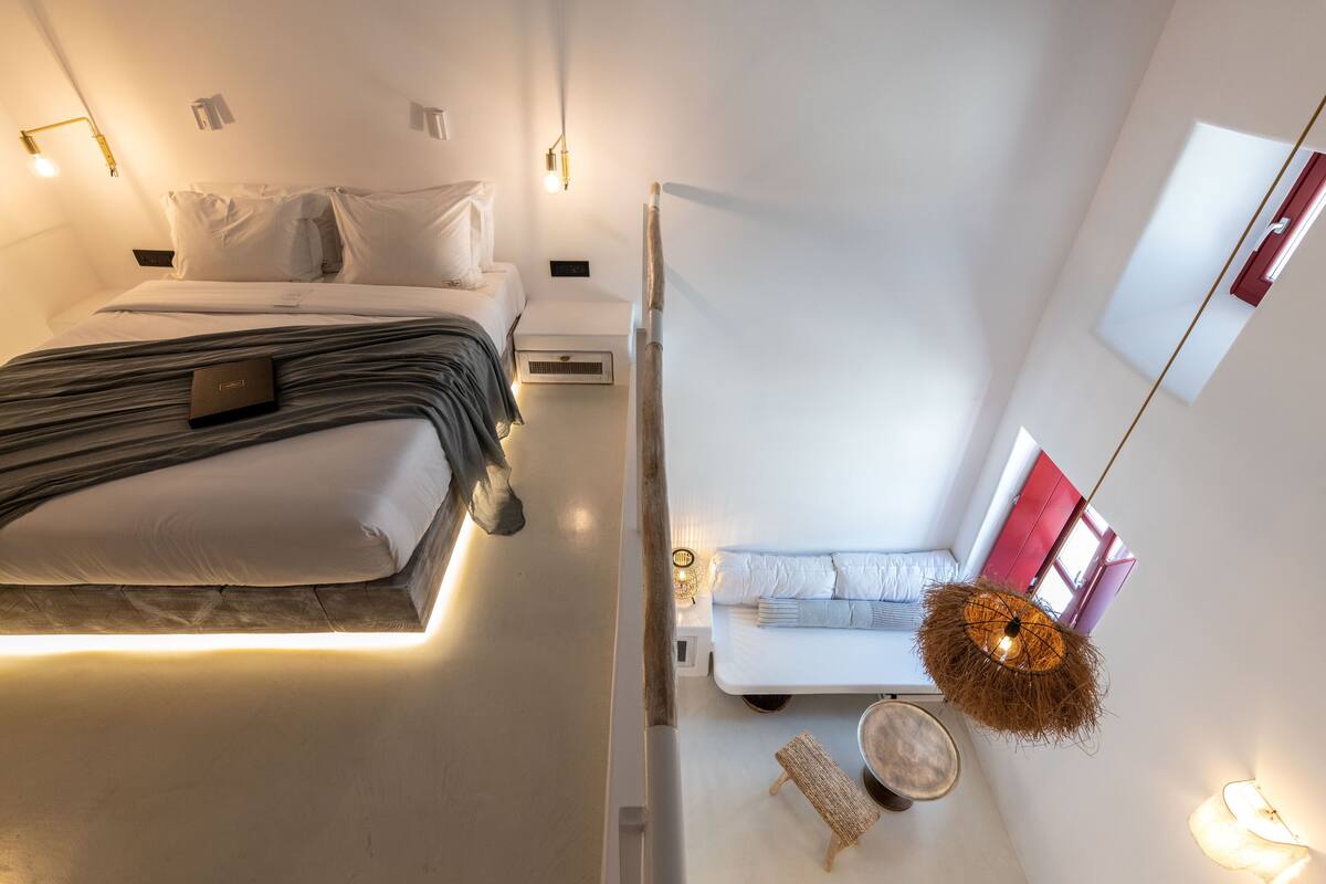 Ein modernes Hotelzimmer mit Bett, Nachttisch und einer Hängelampe.