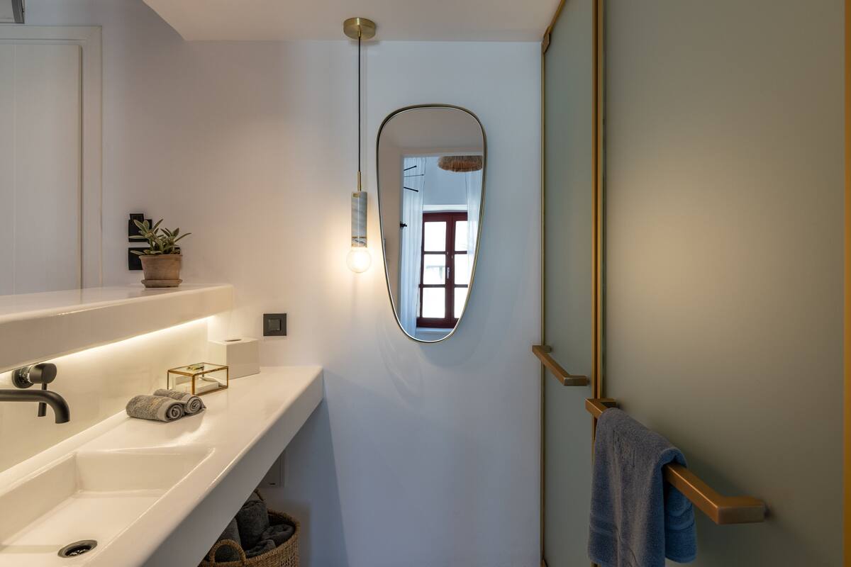 Ein Badezimmer mit einem weißen Waschbecken, einem Spiegel und einem Handtuchhalter.