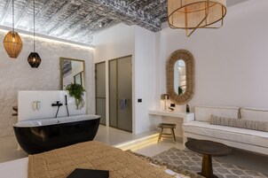 Un baño moderno con una bañera negra, un tocador blanco y un espejo grande.