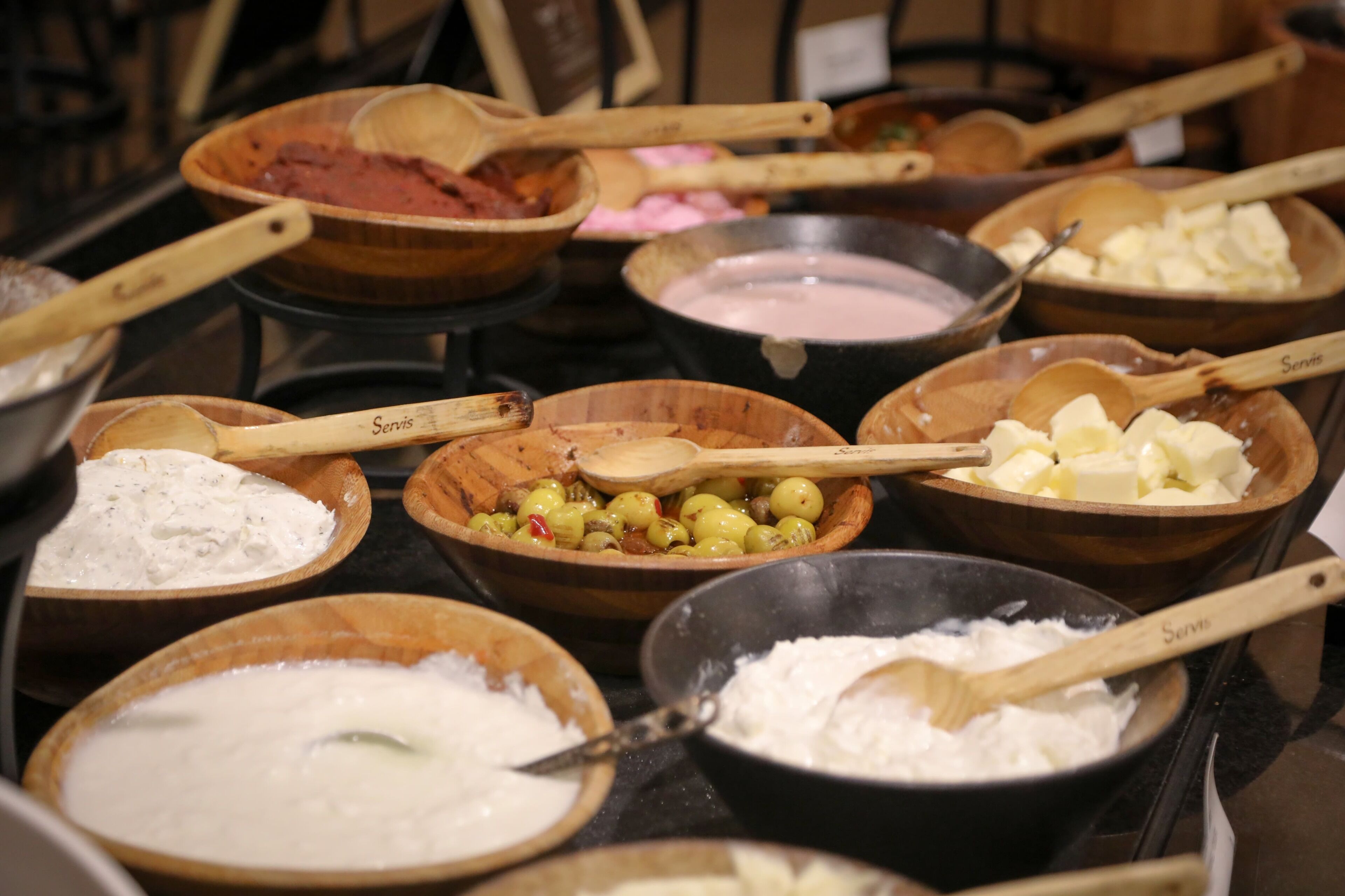 A variety of bowls containing different food items and utensils on a table.