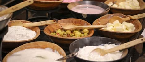 A variety of bowls containing different food items and utensils on a table.