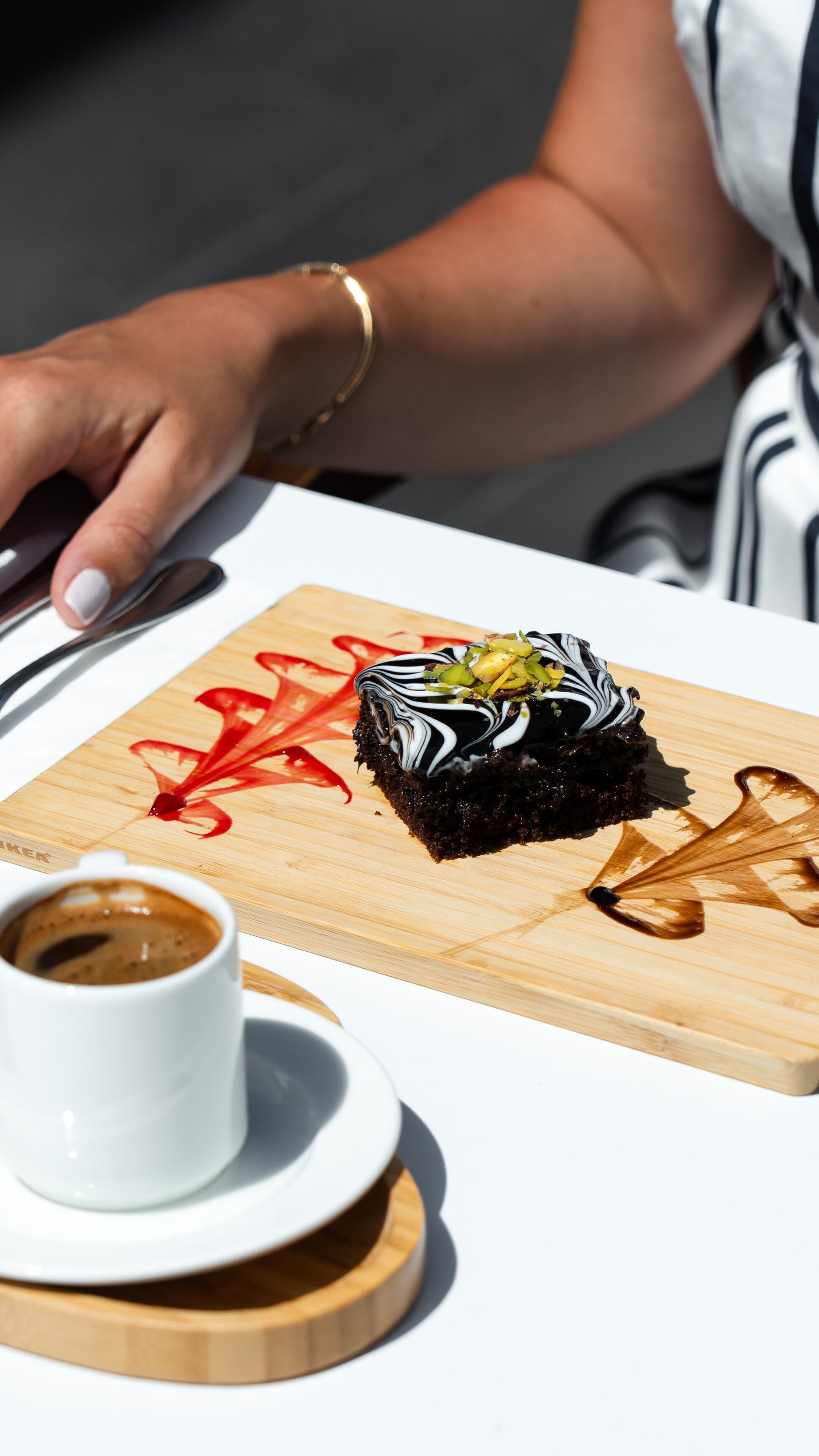 A dessert on a wooden board with a cup of coffee beside it.