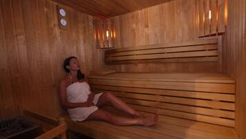 A wooden sauna with benches and a bench for sitting.