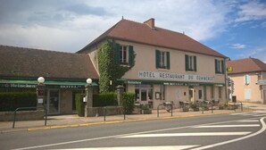 Un edificio con un cartel que dice "HOTEL RESTAURANT DU COMMERCE" y la marca "Heineken".