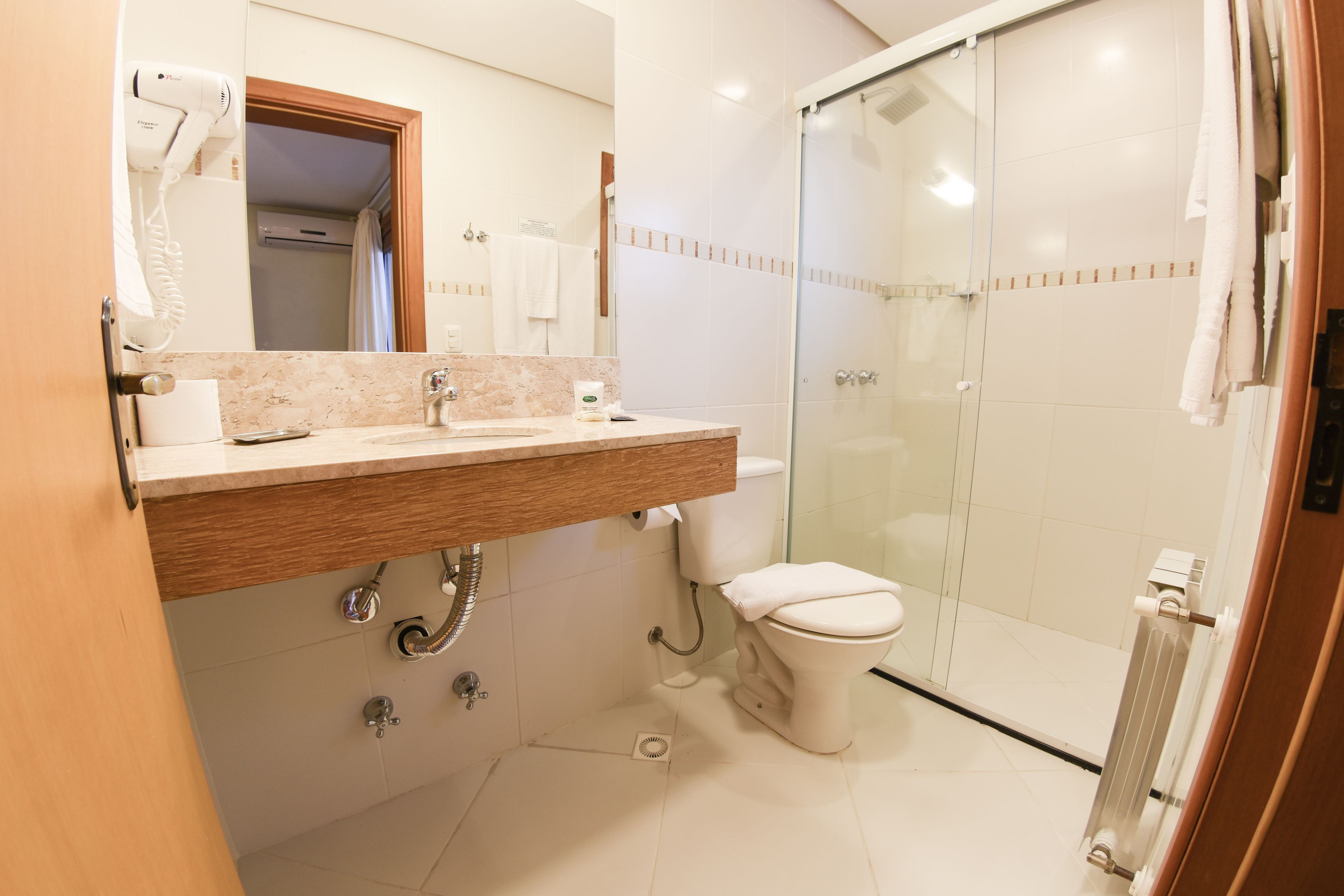 A modern bathroom with a shower, toilet, and sink.