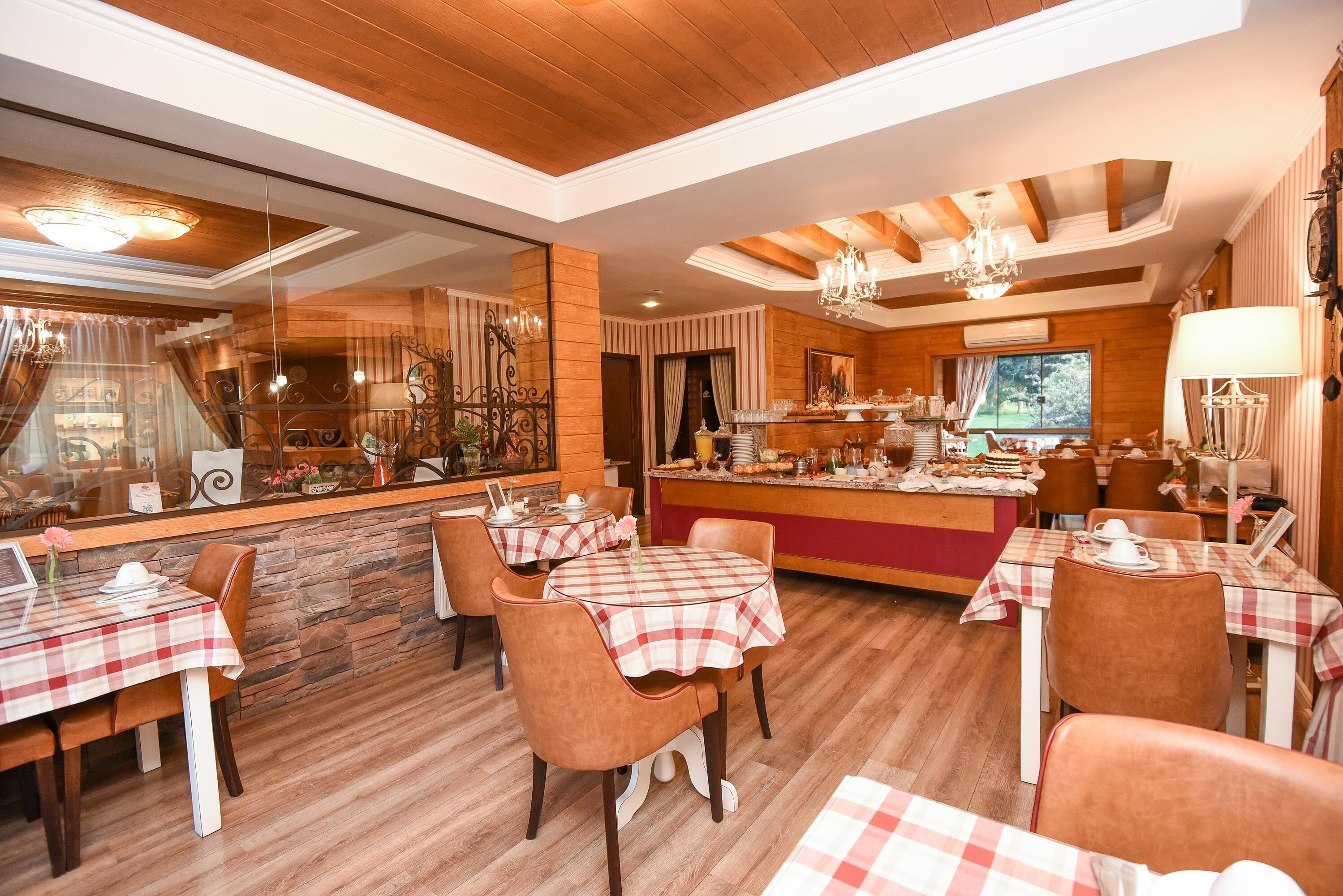 A restaurant with wooden floors, checkered tablecloths, and brown leather chairs.