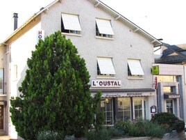A building with a sign reading "L'OUSTAL" and "RESTAURANT" indicating a dining establishment.