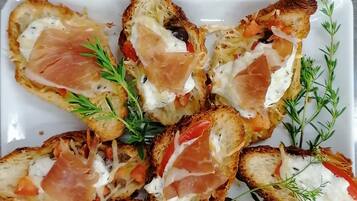 A plate of toasted bread with toppings, garnished with herbs.