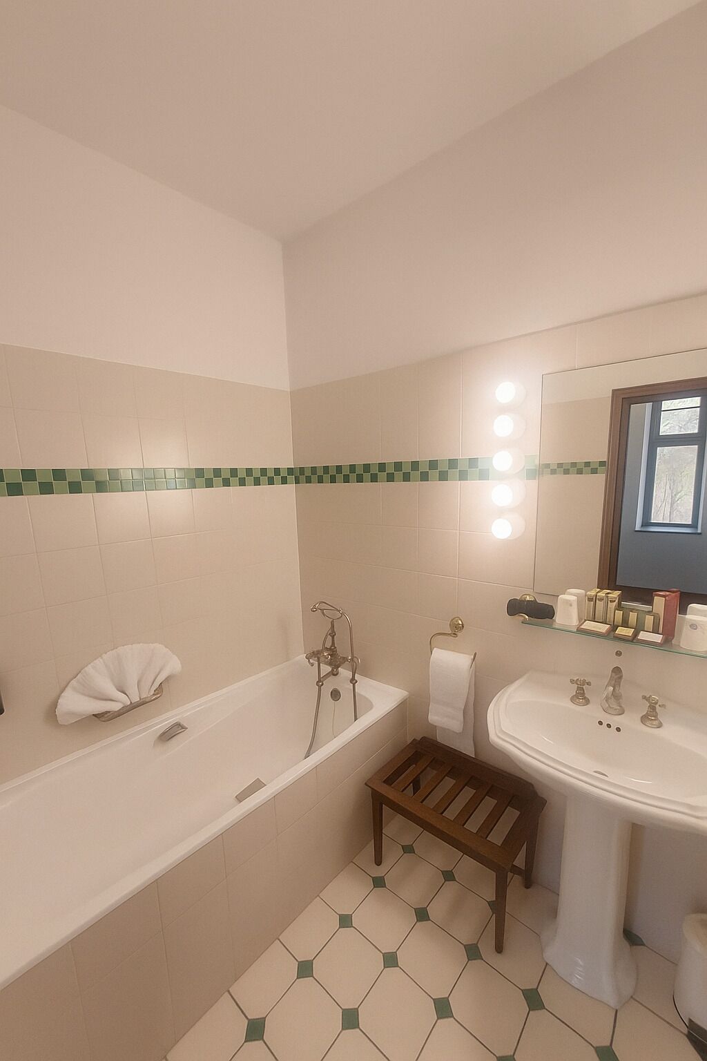 Un baño con bañera, lavabo, tocador y espejo.