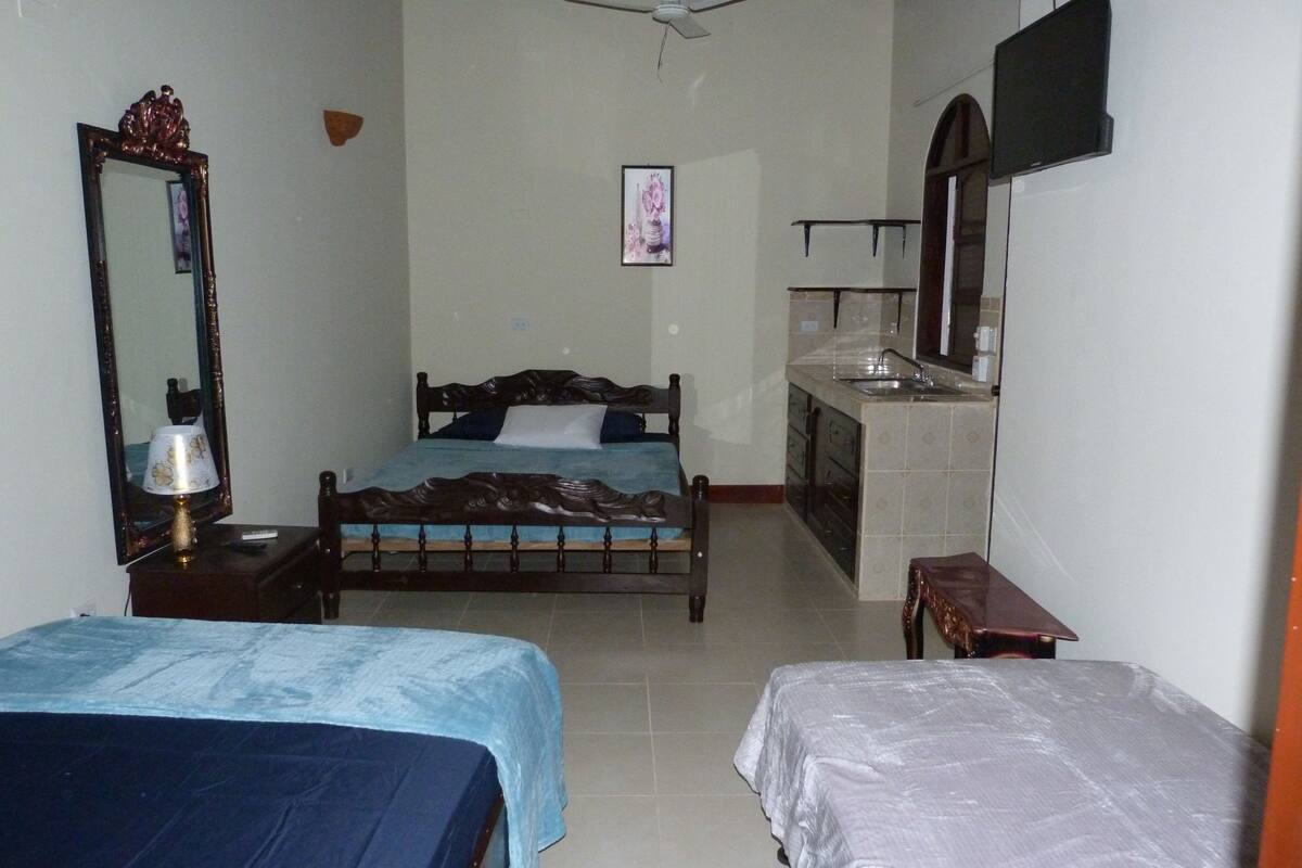 Une chambre à coucher avec un lit, une table de chevet avec une lampe, une commode et un miroir.