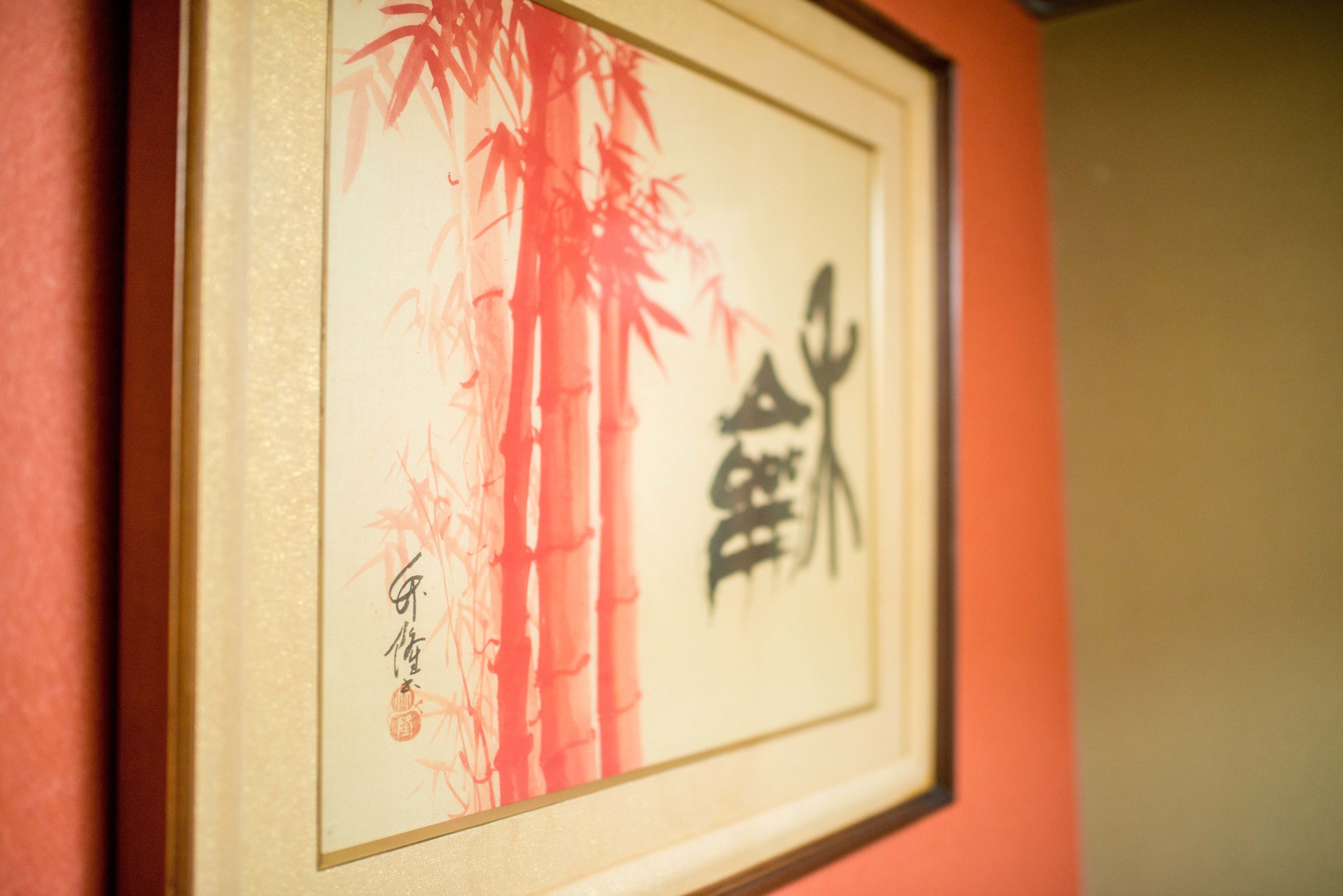 A framed artwork with bamboo and Chinese characters on a wall.