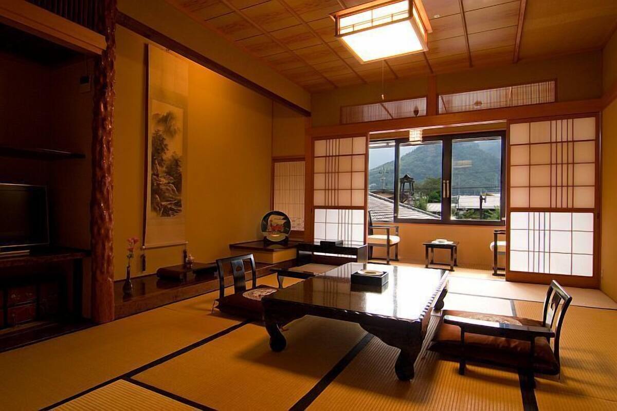 Um quarto japonês tradicional com tatames, uma mesa baixa e portas deslizantes.