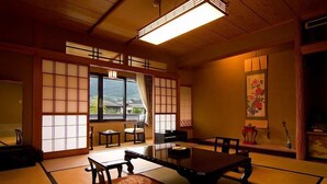 Una habitación japonesa tradicional con suelo de tatami, una mesa baja y puertas correderas.