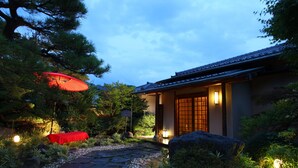 Un edificio tradicional japonés con un camino de piedra que conduce a la entrada.