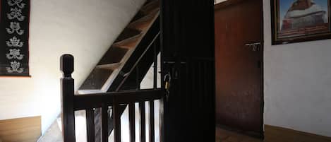 A staircase leading to a room with a wooden door and a framed picture on the wall.